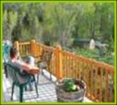 Guest on west deck of Bullion Creekside Cabin overlooking Pine Creek