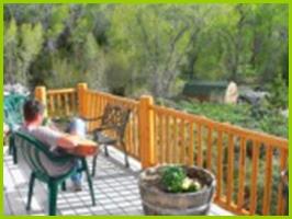 Guest on west deck of Bullion Creekside Cabin overlooking Pine Creek